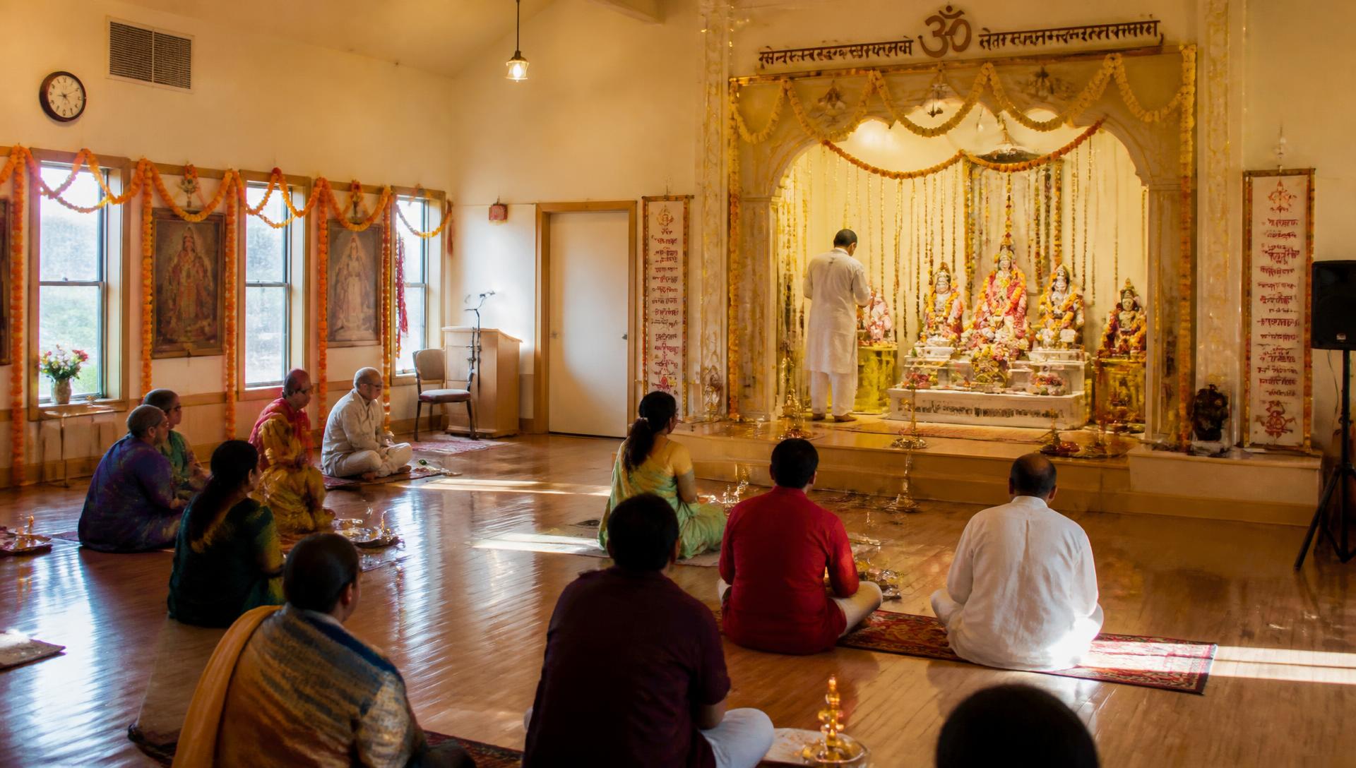 Devotees seated for morning aarti inside Shri Khodiyar Mandir in Pekin, Illinois